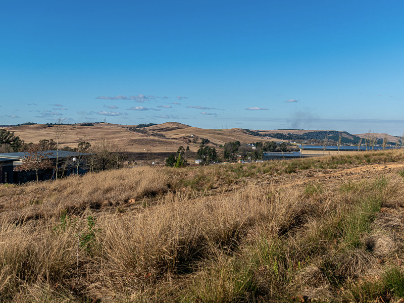 A scenic view overlooking the surrounding rolling hills and landscape from the vacant residential property.