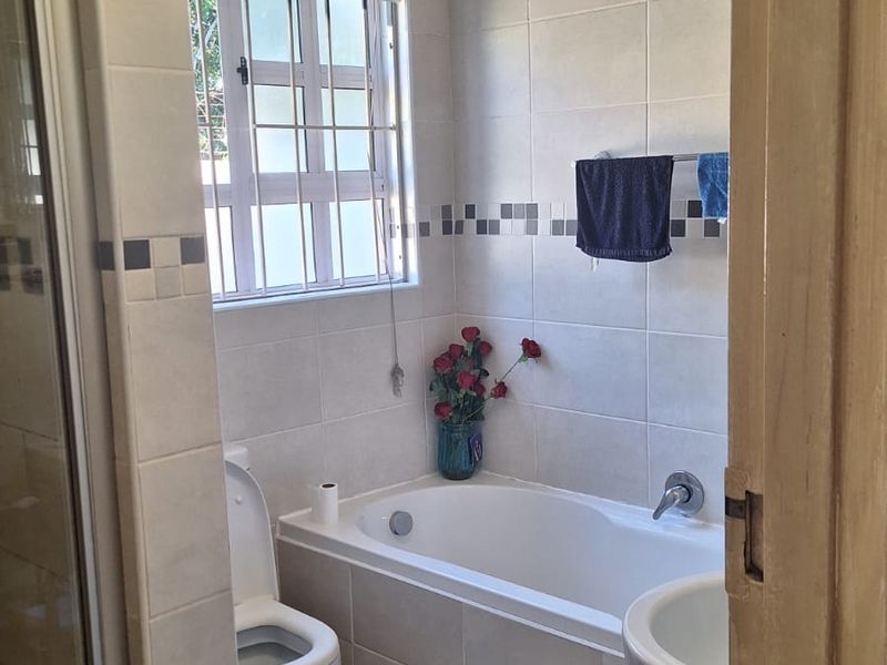 A functional bathroom featuring a built-in bathtub, shower enclosure, and pedestal basin, requiring attention to ceiling finishes.