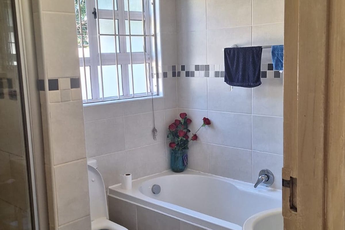 A functional bathroom featuring a built-in bathtub, shower enclosure, and pedestal basin, requiring attention to ceiling finishes.