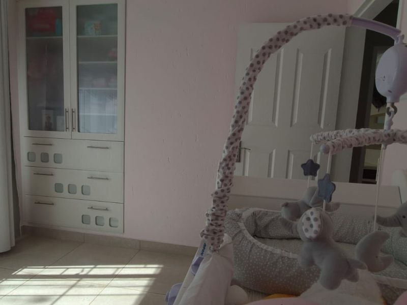 A bedroom featuring tiled flooring and built-in cabinetry, providing functional storage space within the room.