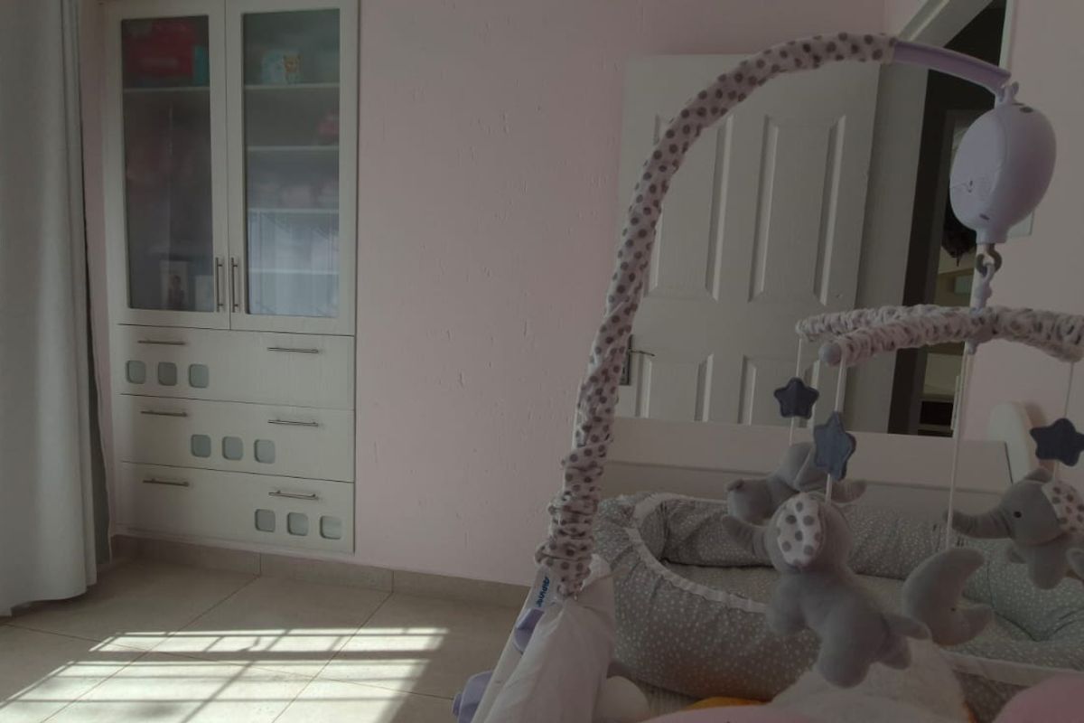 A bedroom featuring tiled flooring and built-in cabinetry, providing functional storage space within the room.