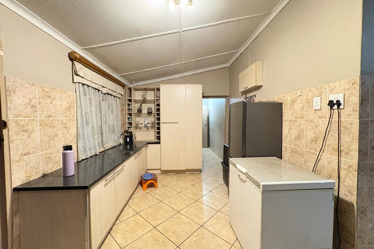 A functional kitchen featuring laminate cabinetry, granite countertops, tiled backsplash, and tiled flooring, offering a practical layout for daily meal preparation.