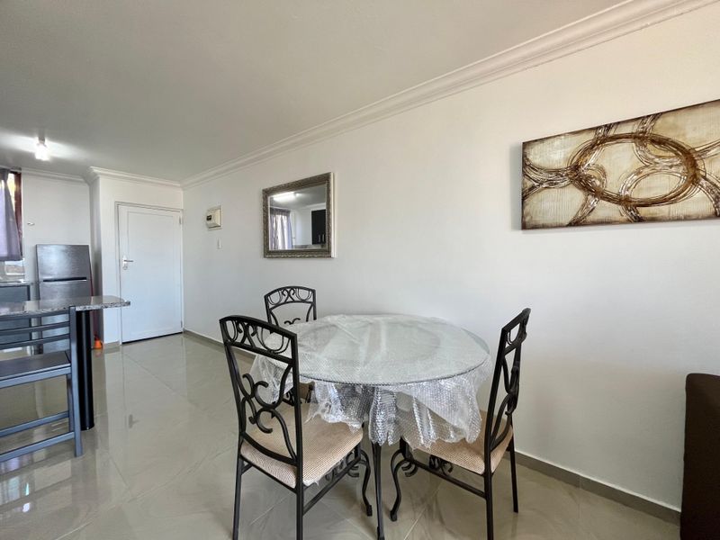 Open plan living and dining area featuring neutral tiled flooring and coved ceilings, providing a functional and versatile space for daily living.