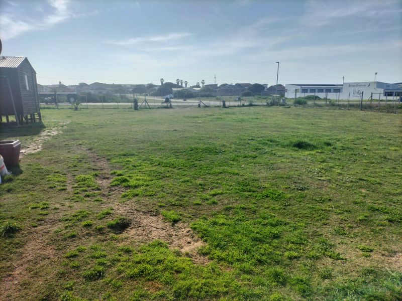 A large, open grass lawn area with perimeter fencing, offering potential for landscaping or outdoor development.