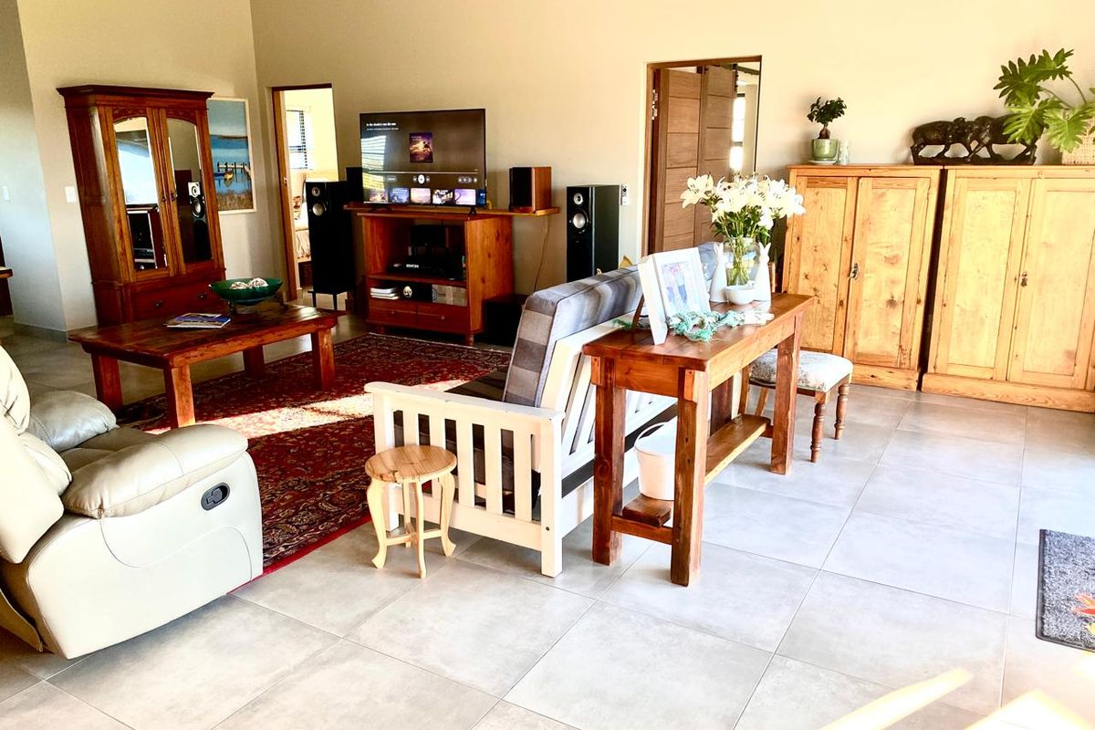 Spacious living room featuring large format floor tiles and high ceilings, offering a bright and open layout suitable for comfortable family living.
