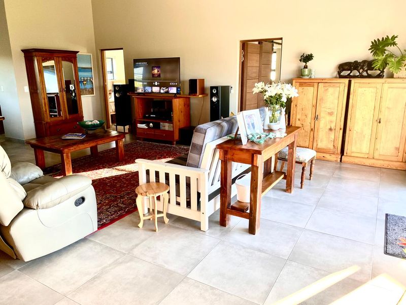 Spacious living room featuring large format floor tiles and high ceilings, offering a bright and open layout suitable for comfortable family living.