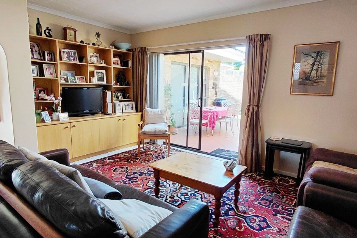 A comfortable living room featuring built-in cabinetry and large sliding glass doors that provide direct access to the outdoor patio area.