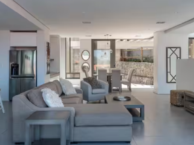 Spacious open-plan living area featuring a modern kitchen, dining space, and lounge, with seamless flow to an outdoor patio and garden area.