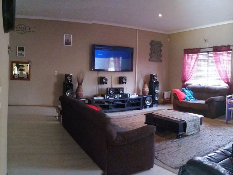 Spacious living room featuring a split-system air conditioner, recessed lighting, and large windows with venetian blinds.