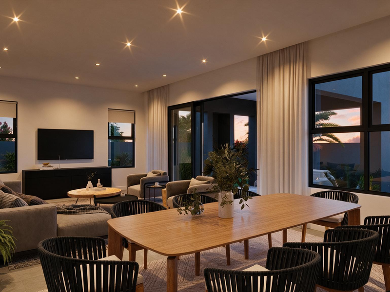 Spacious open-plan living and dining area featuring modern recessed lighting, large windows, and seamless access to the outdoor patio through sliding glass doors.
