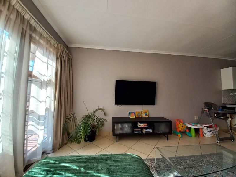Open plan living area featuring tiled flooring and a sliding glass door providing access to the balcony.