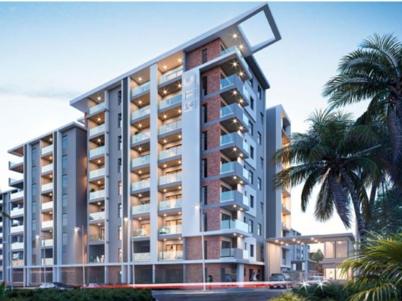 A modern multi-story apartment building featuring contemporary brick and concrete architecture with private balconies and glass balustrades.