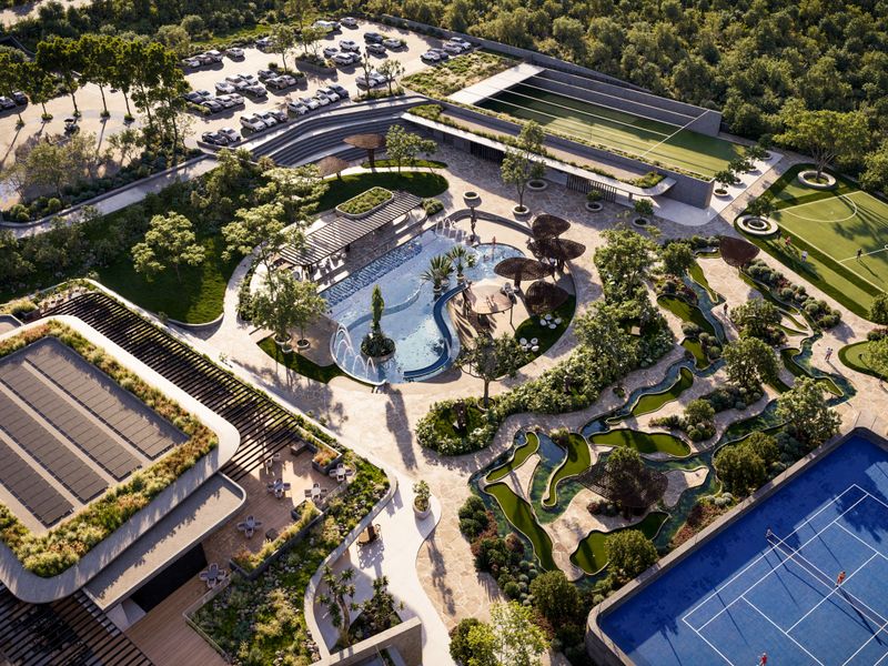 Aerial view of a luxury residential estate featuring a swimming pool, tennis court, soccer field, landscaped gardens, and extensive parking facilities.
