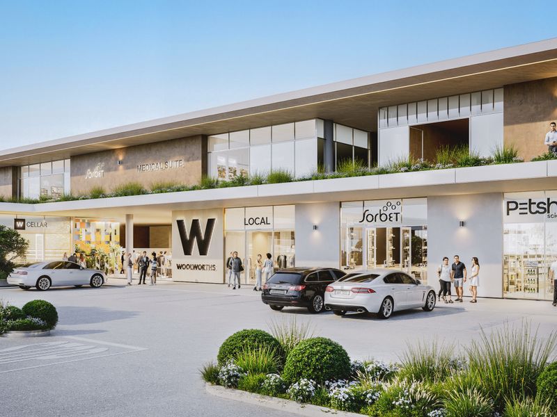 A modern commercial retail center featuring multiple storefronts, paved parking, and professional landscaping in a contemporary architectural design.
