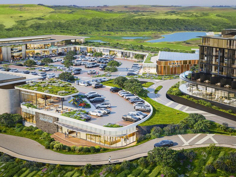 An aerial view of the Zimbali Square commercial development, featuring modern retail buildings, extensive parking facilities, and landscaped green spaces.