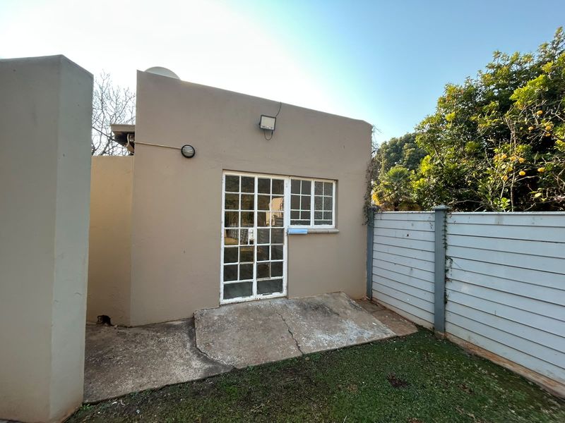 Rear exterior view of the property featuring a concrete patio area, french doors, and a boundary fence.