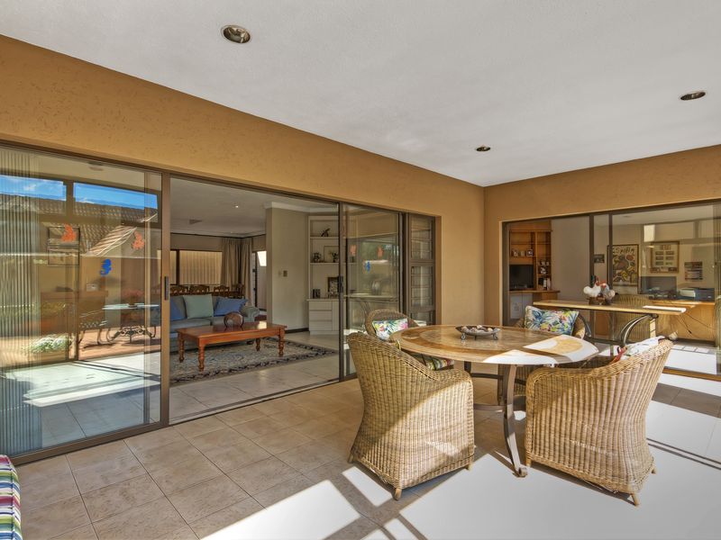 A covered patio area featuring tiled flooring and large sliding glass doors that provide seamless access to the interior living spaces.