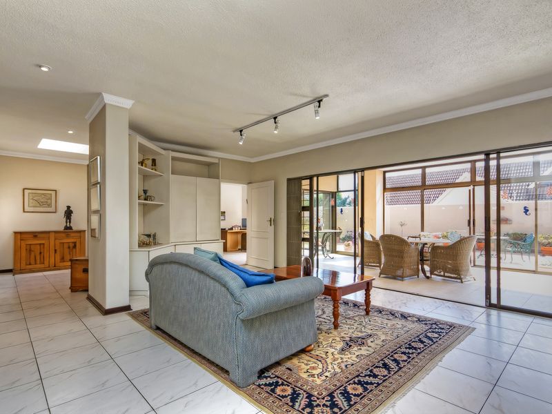 Spacious living area featuring tiled floors, built-in cabinetry, and large sliding glass doors that provide seamless access to the outdoor patio.