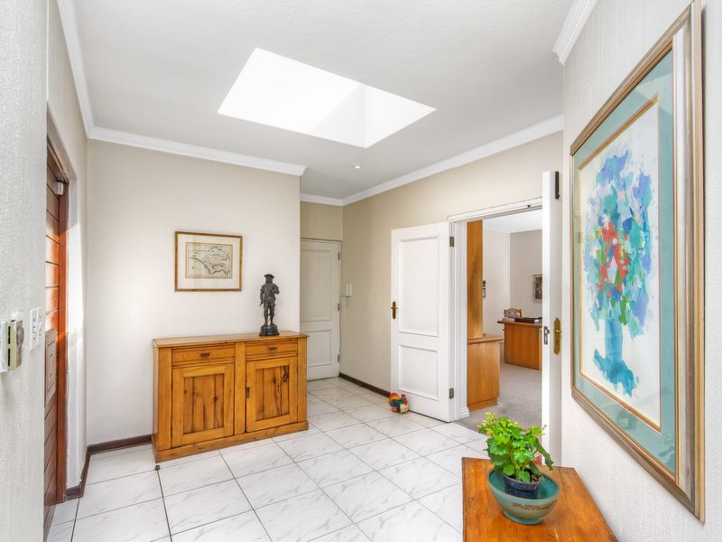 Bright entrance hall featuring tiled flooring, a skylight providing natural illumination, and access to adjacent living spaces.