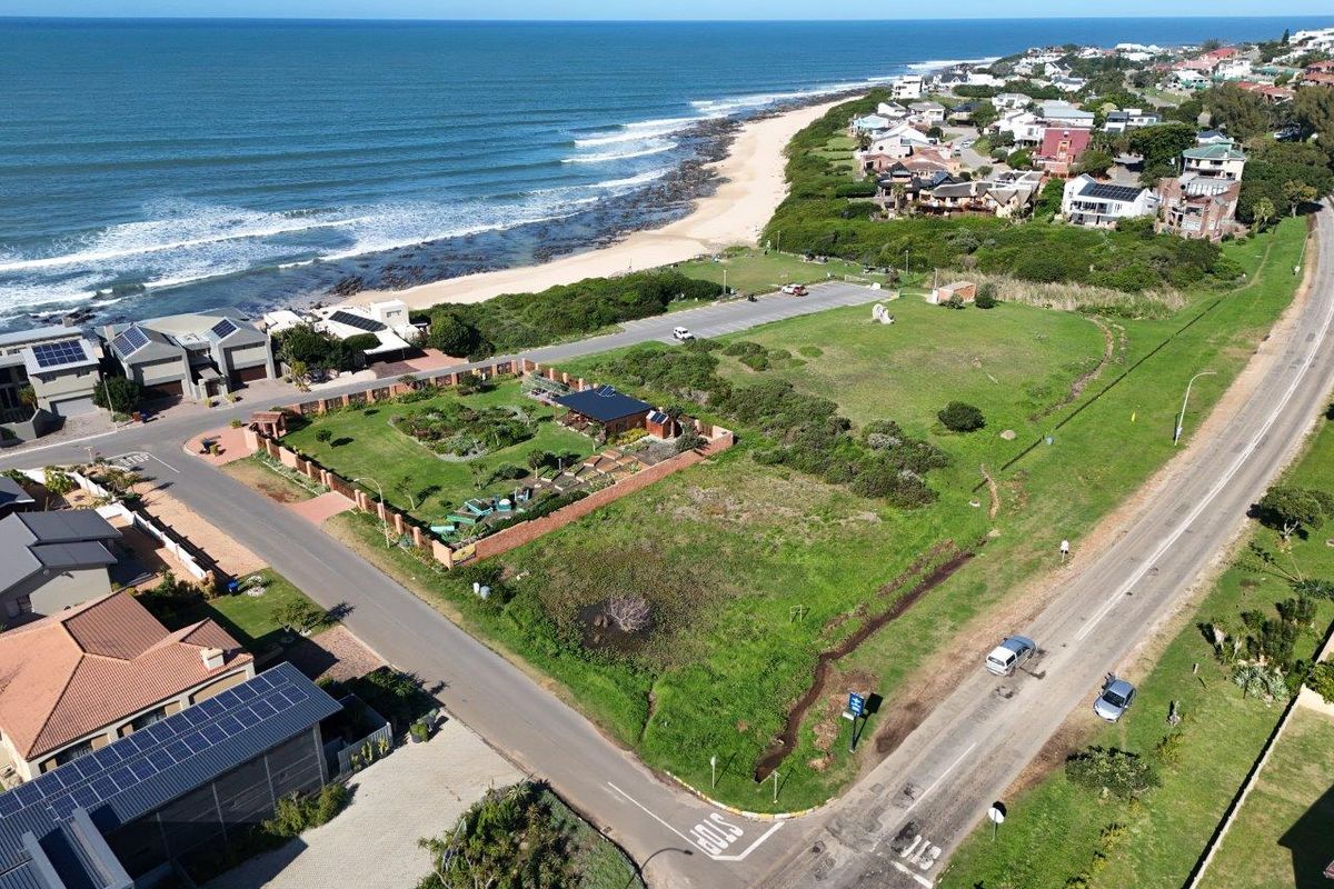 Aerial view of a vacant residential corner plot situated in a coastal neighborhood, offering proximity to the beach and local road infrastructure.