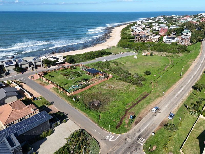 Aerial view of a vacant residential corner plot situated in a coastal neighborhood, offering proximity to the beach and local road infrastructure.
