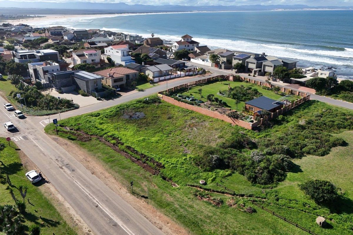 Aerial view of a vacant residential plot situated in a coastal neighborhood, offering proximity to the beach and established local infrastructure.