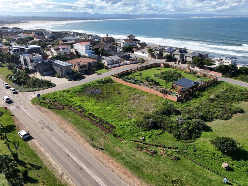 Aerial view of a vacant residential plot situated in a coastal neighborhood, offering proximity to the beach and established local infrastructure.