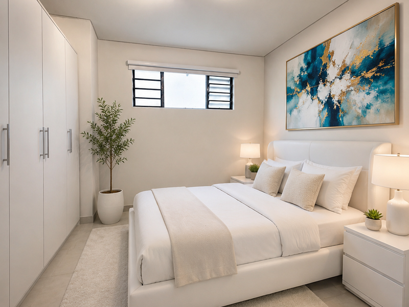 A well-maintained bedroom featuring built-in wardrobes, neutral tiled flooring, and a louvered window, offering a clean and modern living space.