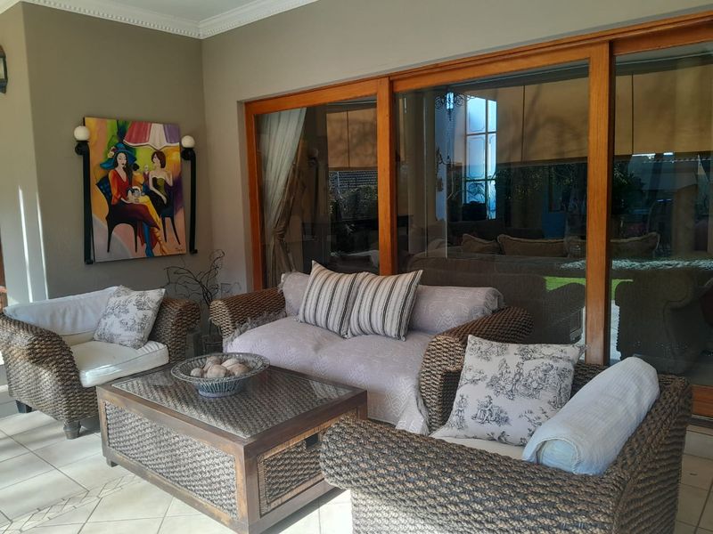 A covered patio area featuring large sliding glass doors and tiled flooring, providing a seamless transition to the outdoor space.