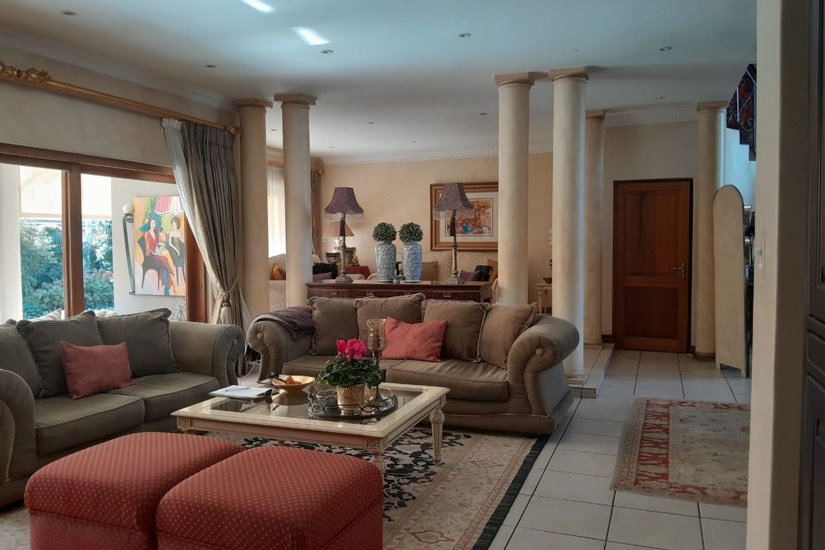 Spacious living area featuring decorative columns, tiled flooring, and large sliding glass doors that provide access to the outdoor space.