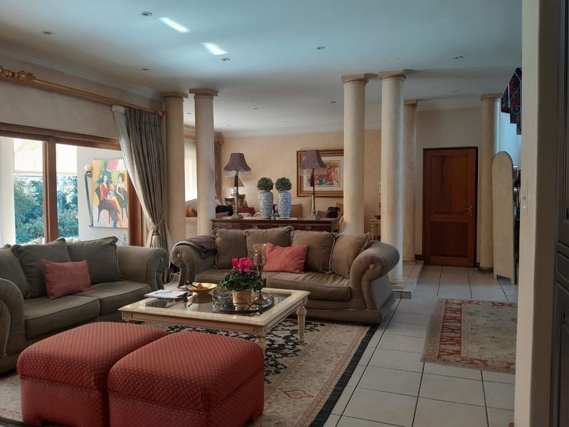 Spacious living area featuring decorative columns, tiled flooring, and large sliding glass doors that provide access to the outdoor space.