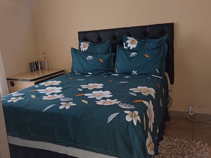 A compact bedroom featuring tiled flooring and neutral wall finishes, providing a functional space for rest.