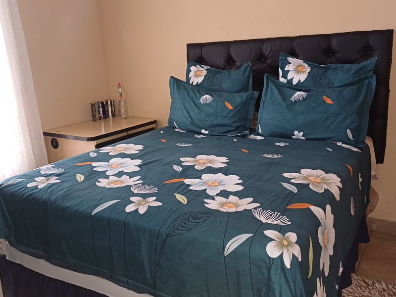 A functional bedroom featuring tiled flooring and neutral wall finishes, providing a comfortable and practical sleeping space.