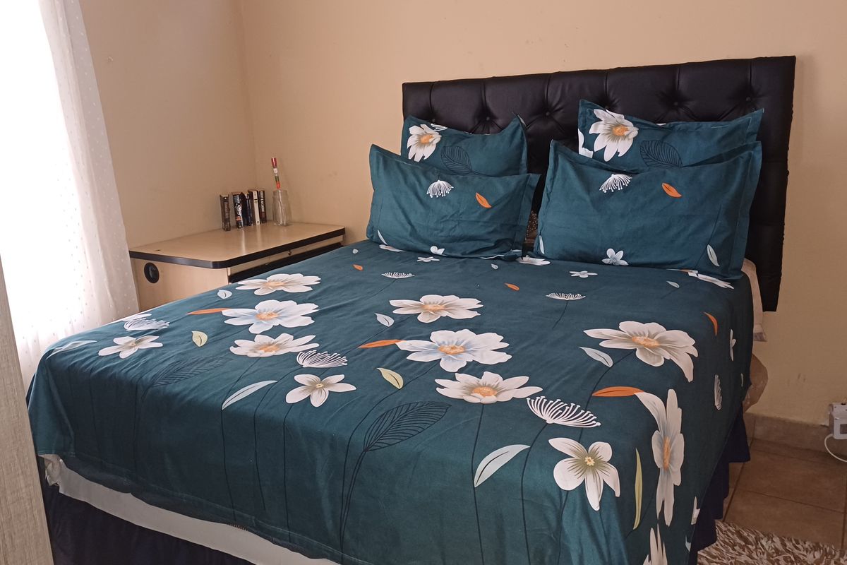 A functional bedroom featuring tiled flooring and neutral wall finishes, providing a comfortable and practical sleeping space.
