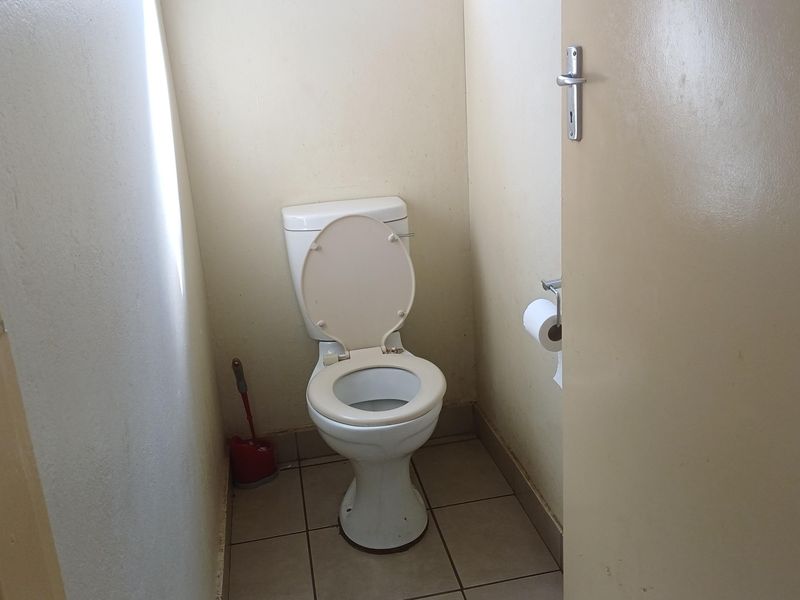 A functional, compact bathroom featuring a standard toilet and tiled flooring.