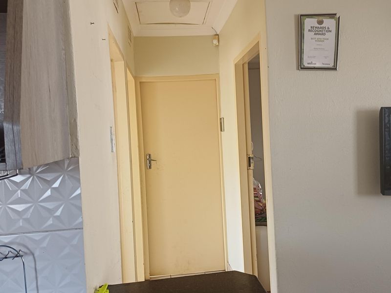 A functional hallway area connecting interior rooms, featuring standard internal doors and a ceiling access hatch.
