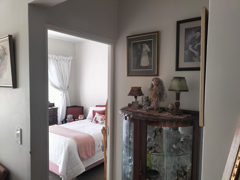 A view from a hallway looking into a bedroom, featuring neutral wall finishes and standard architectural transitions.