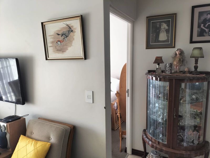A view of a living room interior showing a doorway leading to an adjacent bedroom space with neutral wall finishes.