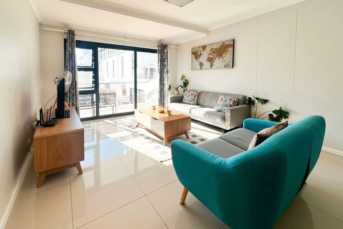 A bright and well-maintained living room featuring large sliding glass doors that provide natural light and access to an outdoor area.