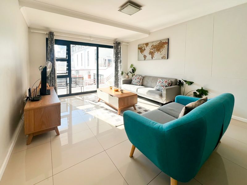 A bright and well-maintained living room featuring large sliding glass doors that provide natural light and access to an outdoor area.