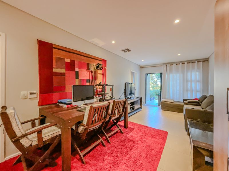 Open-plan living area featuring tiled flooring, recessed lighting, and direct access to an outdoor patio through a sliding glass door.