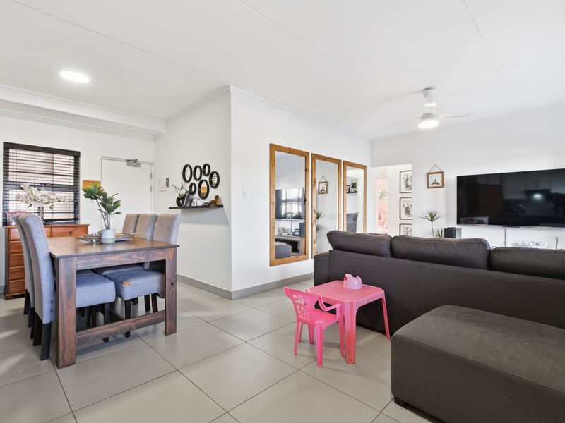 Spacious open-plan living and dining area featuring neutral tiled flooring, modern ceiling fan, and recessed lighting, creating a bright and functional living space.