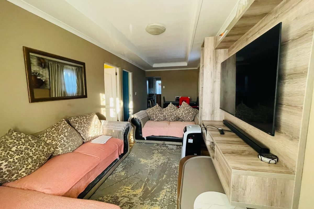 A comfortable living room featuring a built-in media unit and coved ceiling, providing a functional space for relaxation and entertainment.