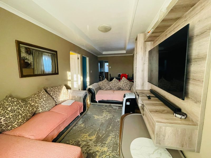 A comfortable living room featuring a built-in media unit and coved ceiling, providing a functional space for relaxation and entertainment.