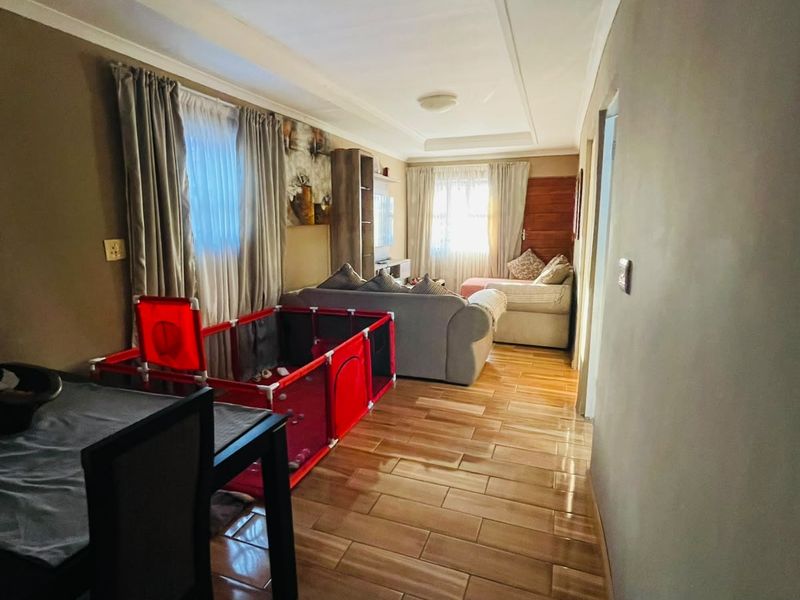 Open plan living area featuring tiled flooring and coved ceilings, providing a versatile space for dining and relaxation.