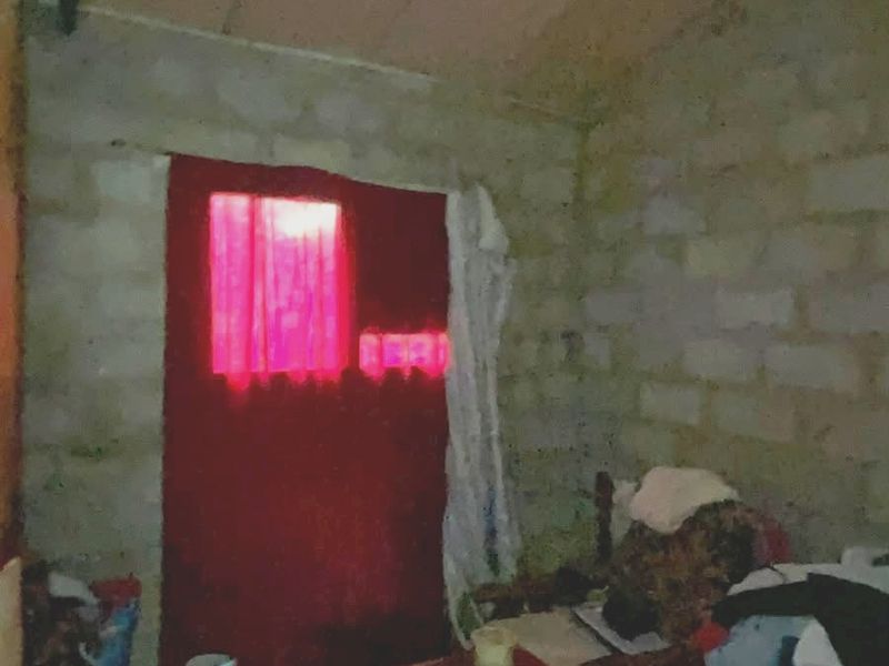 A basic room featuring exposed concrete block walls and an unfinished ceiling, requiring significant renovation and finishing to reach a habitable standard.
