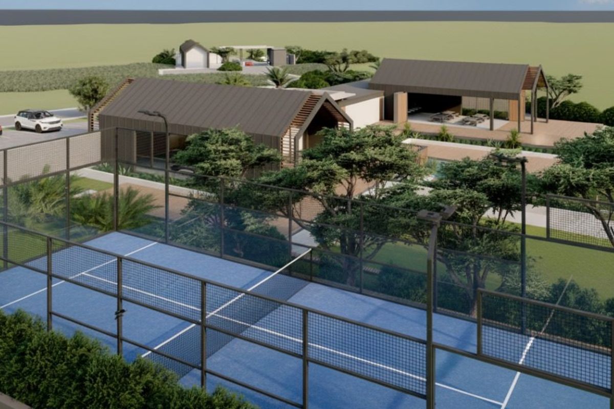 An aerial perspective of a residential development featuring a padel court, swimming pool, landscaped gardens, and modern architectural structures.
