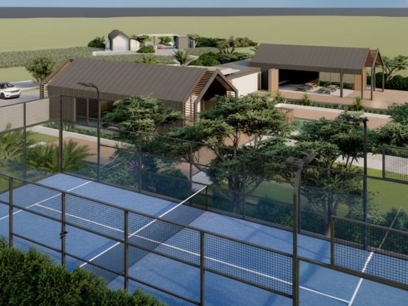 An aerial perspective of a residential development featuring a padel court, swimming pool, landscaped gardens, and modern architectural structures.