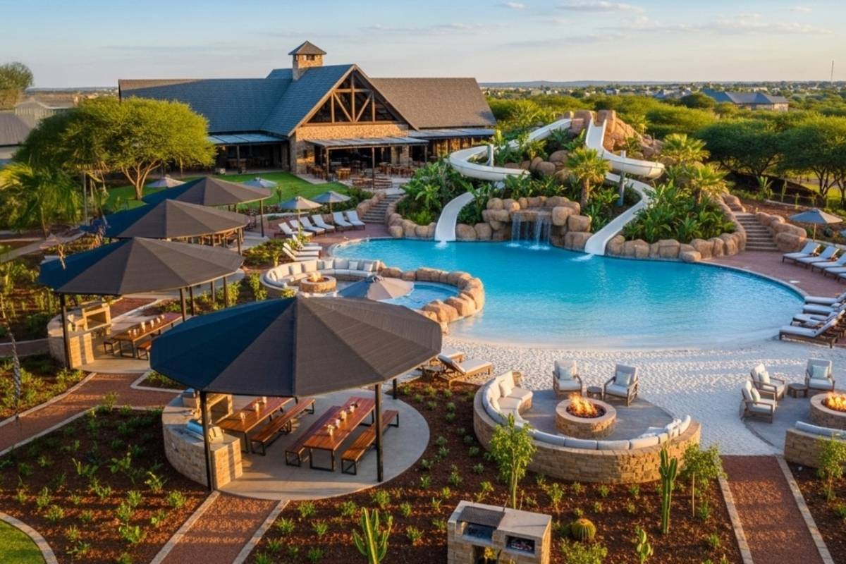 Expansive resort-style pool area featuring a water slide, rock waterfall, multiple fire pits, outdoor kitchen facilities, and beautifully landscaped surroundings.