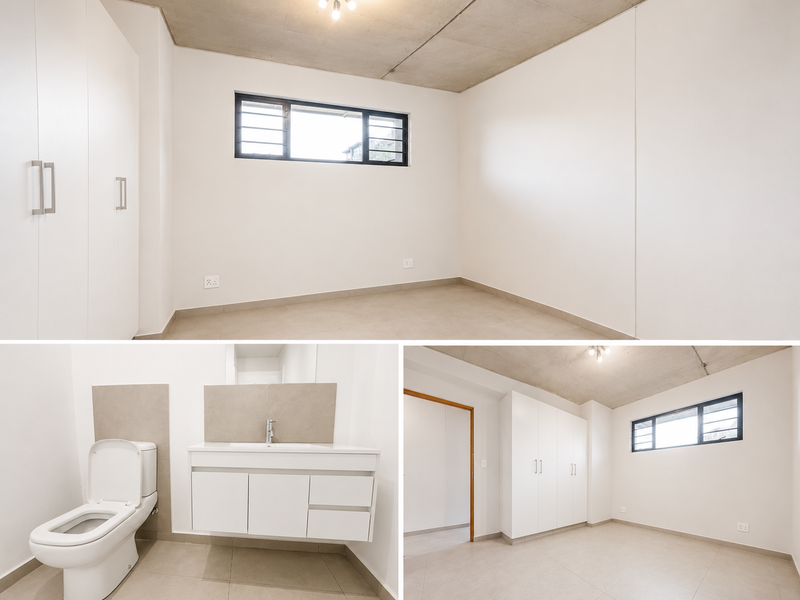 A bright, modern bedroom featuring built-in cupboards, tiled flooring, and an exposed concrete ceiling, offering a clean and minimalist living space.
